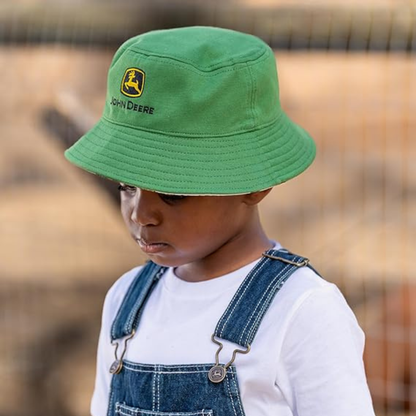 Child wearing a green John Deere hat with a blurred outdoor background